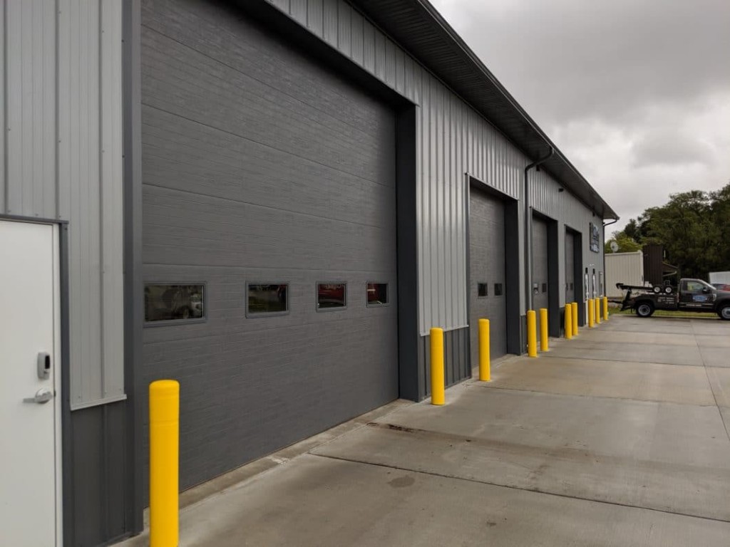 Bollards Post-frame commercial building with bollards protecting overhead doors and exterior walls.