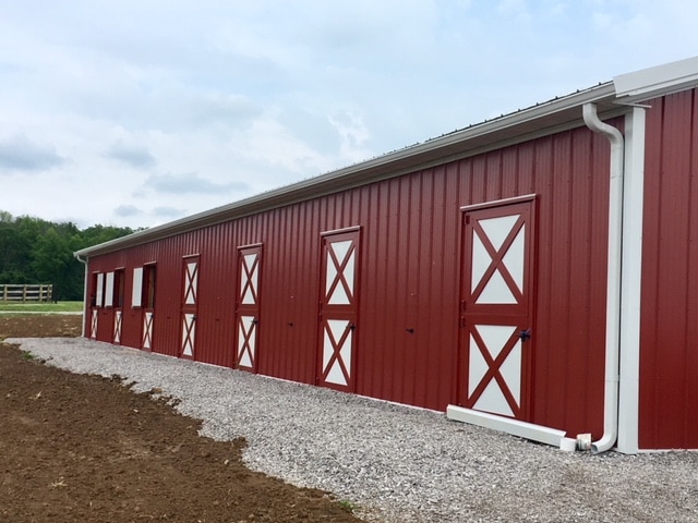Dutch Doors Post-frame horse barn with multiple Dutch doors along the sidewall.