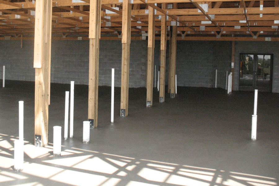Pole barn foundation design with concrete pad and interior support posts.