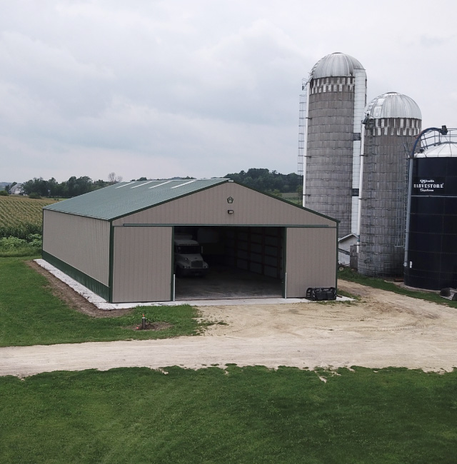 Agricultural equipment storage pole barn with sliding doors on a working farm in Augusta Wisconsin
