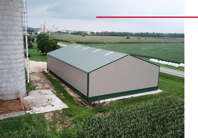 Rear exterior of agricultural equipment storage building near farm silo