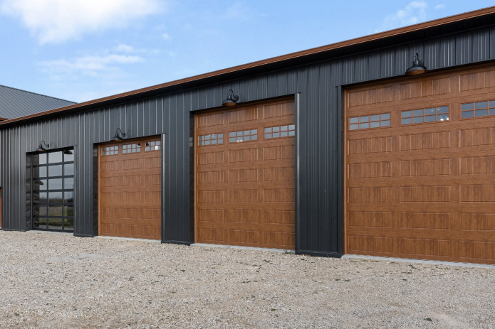 Barndominium Garage with Wood Overhead Doors Barndominium garage with black steel siding and wood overhead garage doors