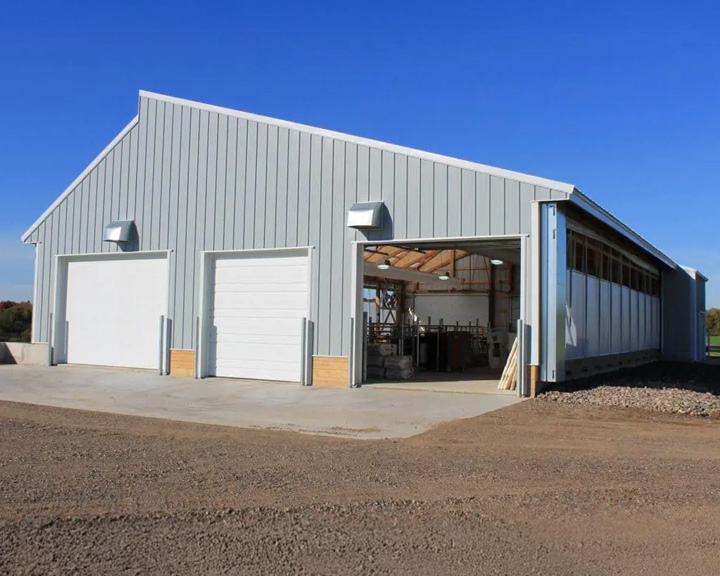 Custom cattle barn with overhead doors and open layout designed for livestock operations and equipment access