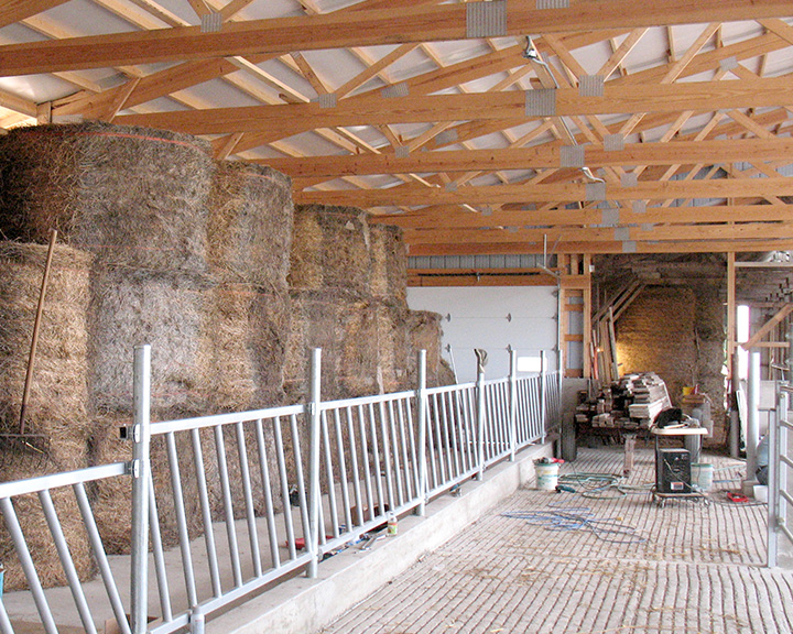 Interior cattle barn with hay storage and feeding area designed for livestock operations and efficiency