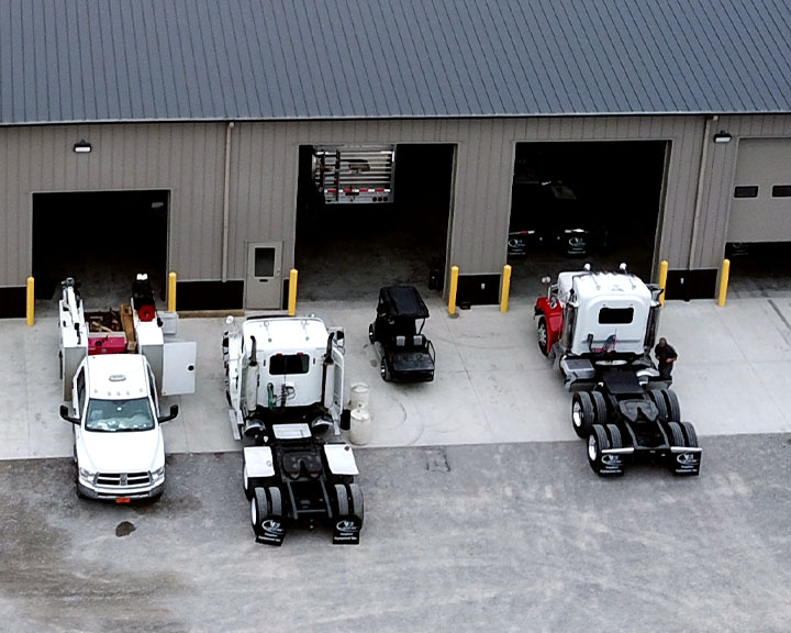 Truck service shop with steel building, open overhead doors, and multiple service bays