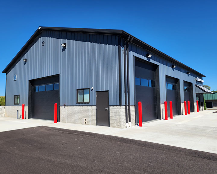 Auto repair shop building with steel siding, tall overhead doors, and multiple service bays