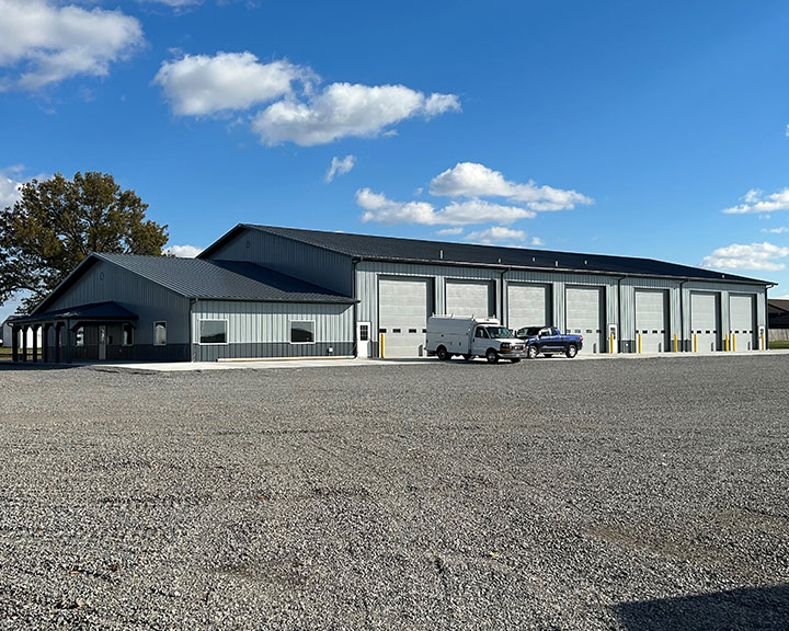 Large auto repair facility with steel siding, multiple overhead doors, and attached office area