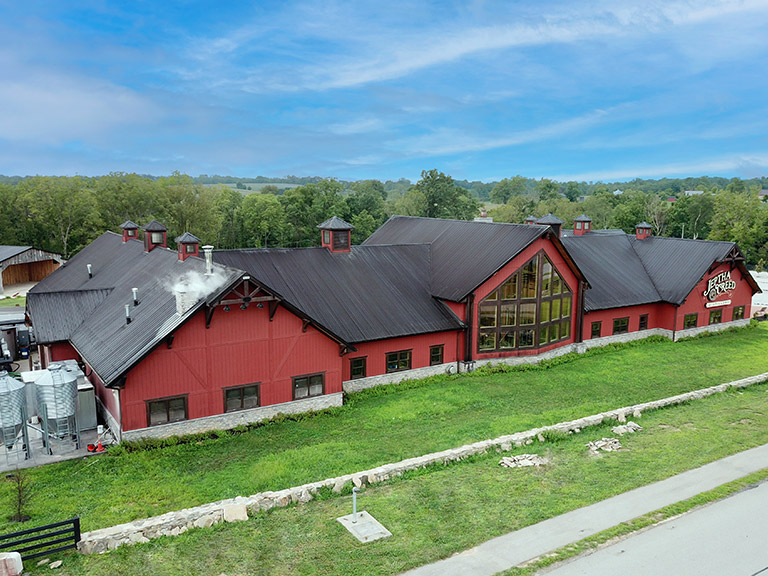 Commercial Distillery with Tasting Room Windows and Cupolas | Walters Buildings Commercial distillery building with steel siding, large windows, and cupolas for ventilation