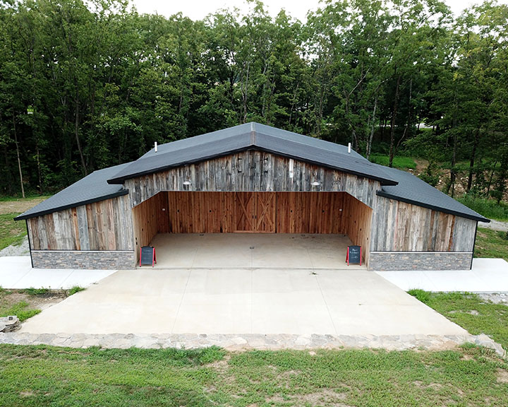 Commercial winery building with rustic wood siding, open pavilion, and covered event space