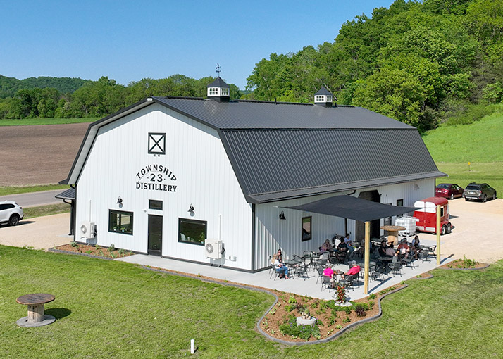 Commercial Distillery with Outdoor Patio and Guest Seating | Walters Buildings Commercial distillery with steel siding, outdoor seating area, and covered patio for guests