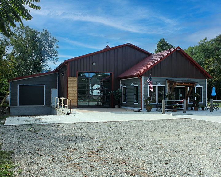 Retail building with steel siding, storefront windows, and covered customer entrance