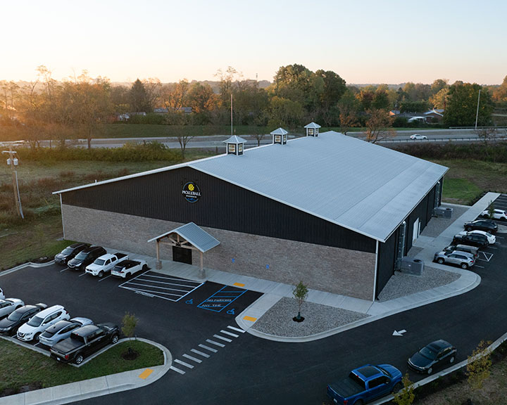 Retail recreation building with steel siding, parking area, and customer entrance