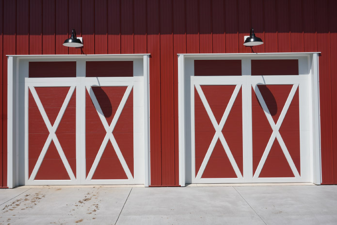 Equipment Storage Building with White Overhead Doors | Walters Buildings The interior of this equipment storage building features a wide-open layout designed to accommodate tractors, utility vehicles, and workshop space. With high ceilings, durable concrete flooring, and natural light from windows, the building provides a functional and efficient environment for equipment storage and daily use.