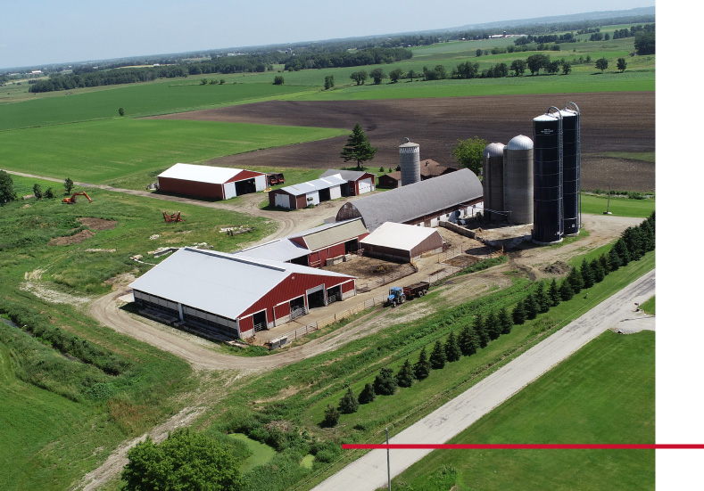 Aerial view of dairy stall barn with silos and surrounding farmland