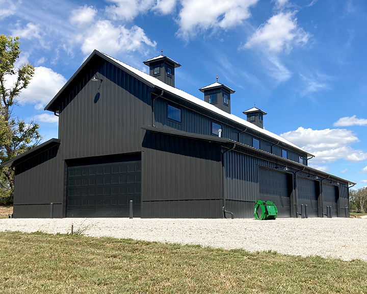 Large machinery storage building with multiple overhead doors designed for equipment access and high-capacity storage