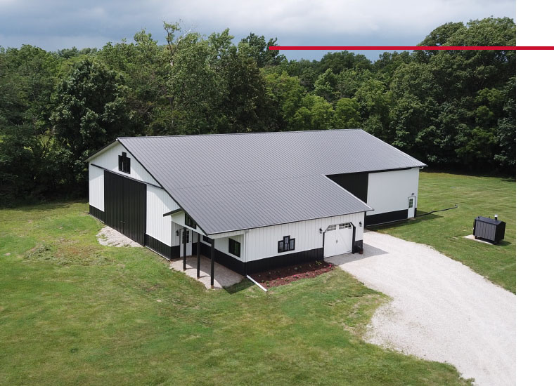 Equipment Storage Building Aerial View with Driveway Access | Walters Buildings Equipment storage building aerial view with large access door, covered porch, and gravel driveway