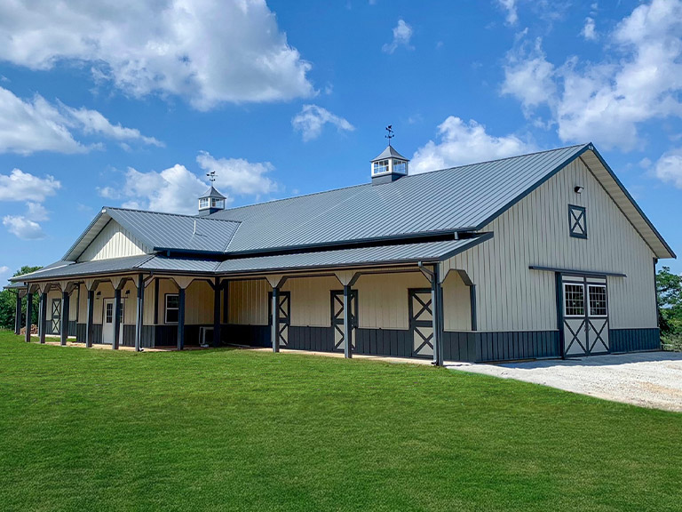 Custom Horse Barn with Covered Porch | Walters Buildings Custom horse barn with covered porch and ventilation cupolas designed for equestrian comfort and daily care