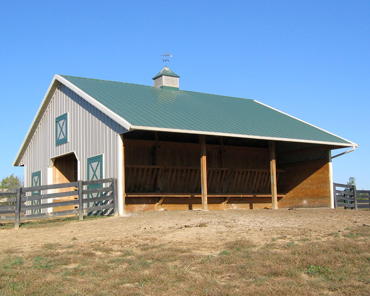Horse barn with open-sided feeding area and covered shelter designed for equestrian care and protection