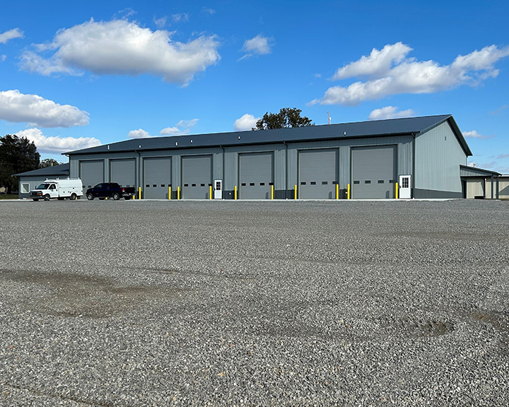 Industrial building with steel siding, multiple overhead doors, and high-clearance service bays