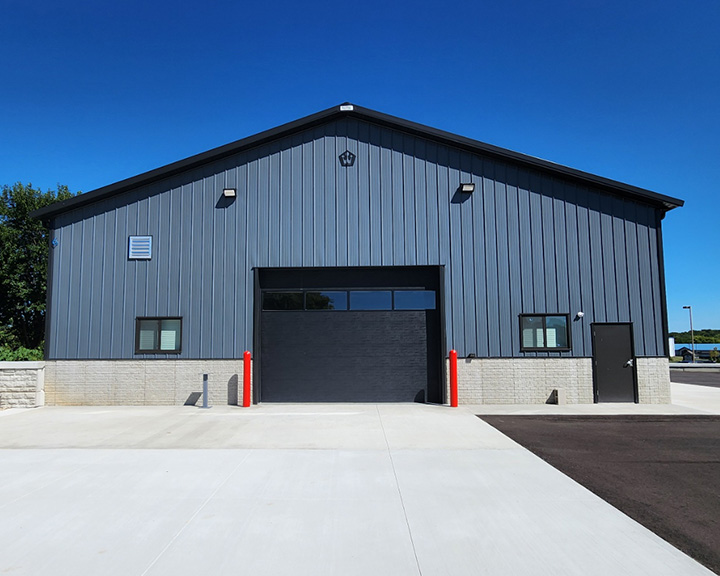 Industrial building with steel siding, overhead door, and high-clearance service bay