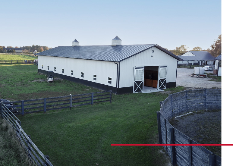 Exterior view of a white stall barn at Integrity Farms