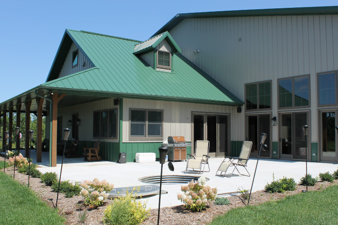Hunting cabin patio with seating area and green metal roof exterior