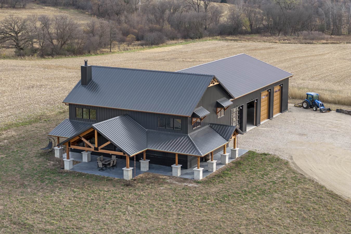 Black steel barndominium with attached workshop and large overhead garage doors