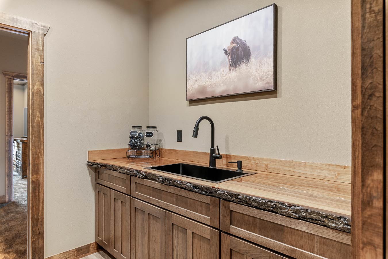 Barndominium wet bar with wood cabinetry and rustic countertop