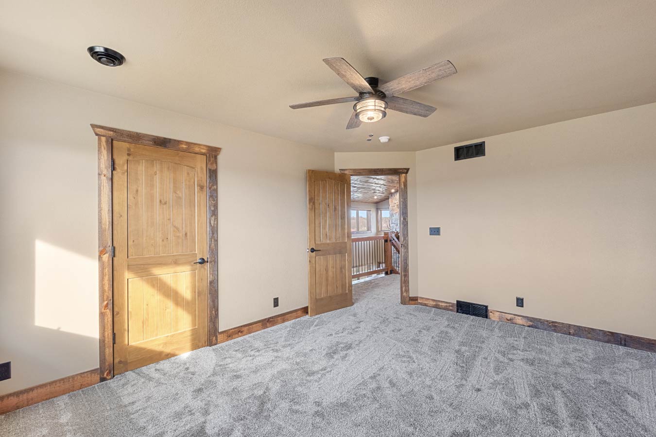 Barndominium bedroom with carpet flooring and rustic wood trim