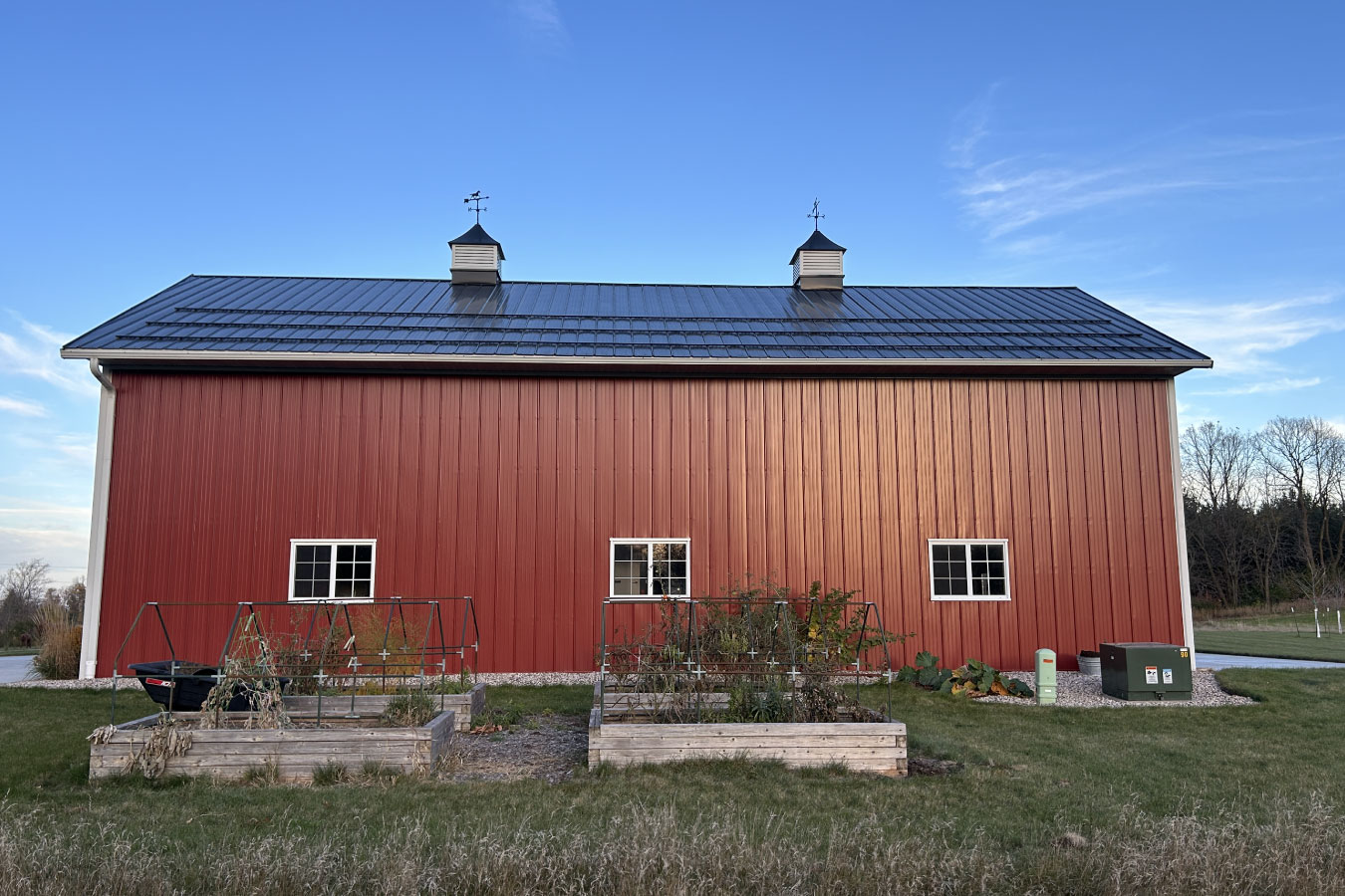 Equipment storage building side view with windows, metal siding, and utility access