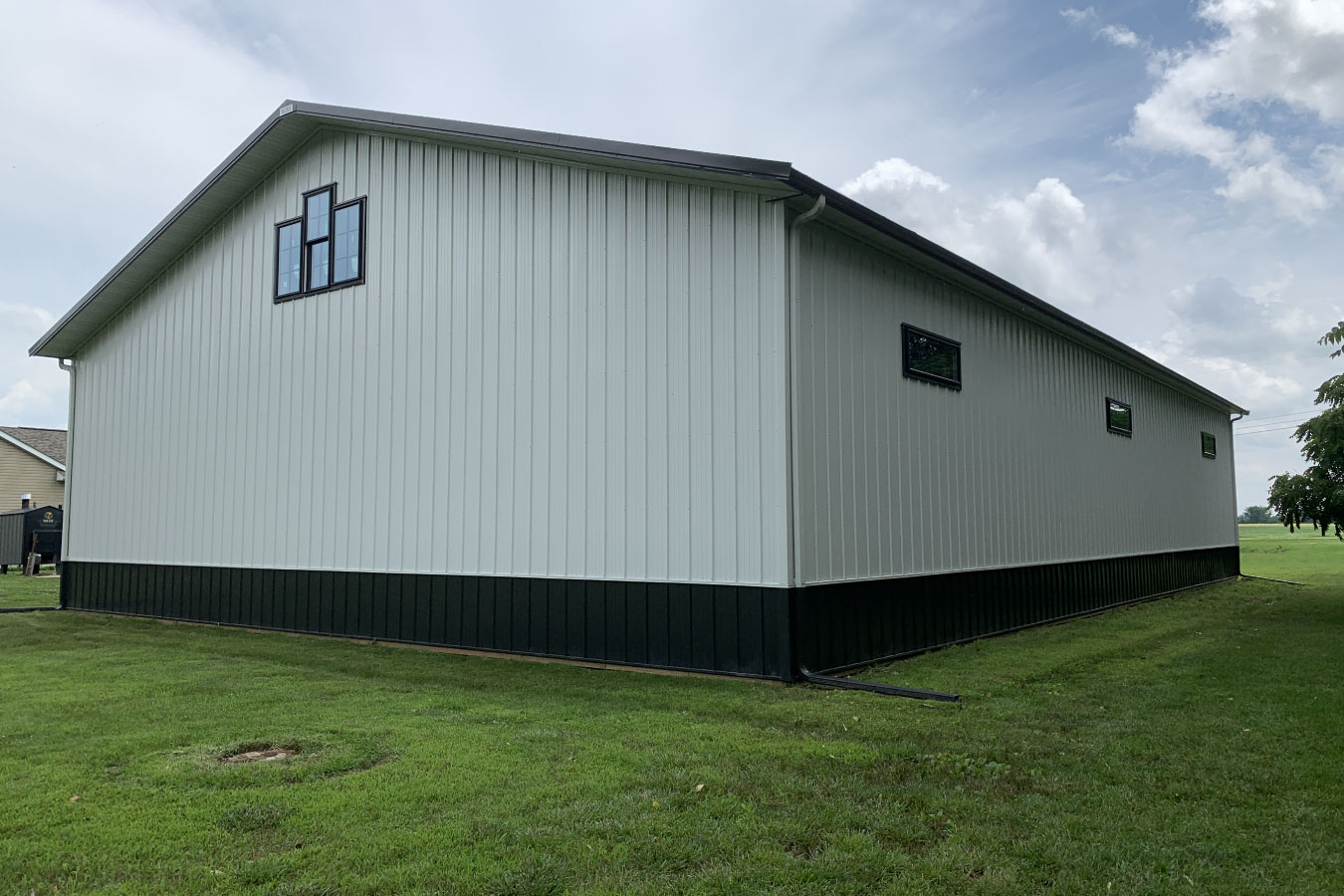 Equipment storage building endwall with upper windows and open yard