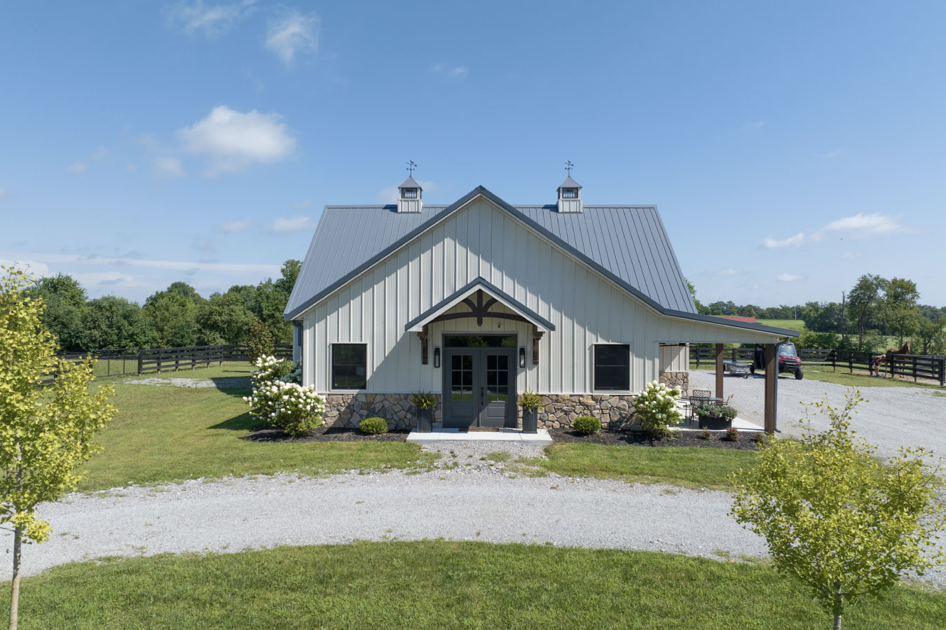 Front view of custom horse barn with living quarters and metal roof