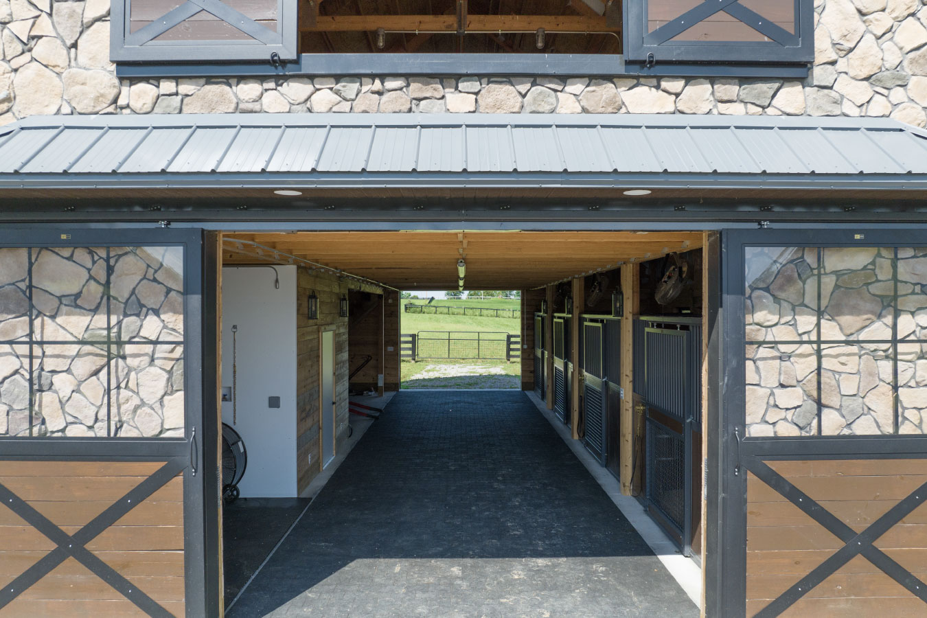 Horse barn aisle with sliding barn doors and horse stalls