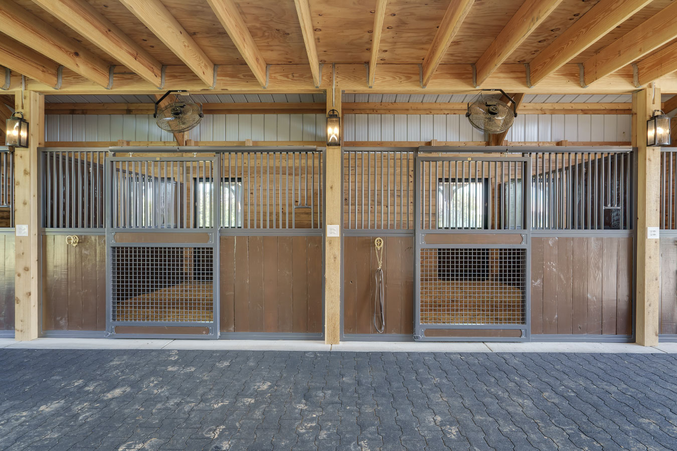 Horse barn stalls with metal fronts and timber post-frame interior