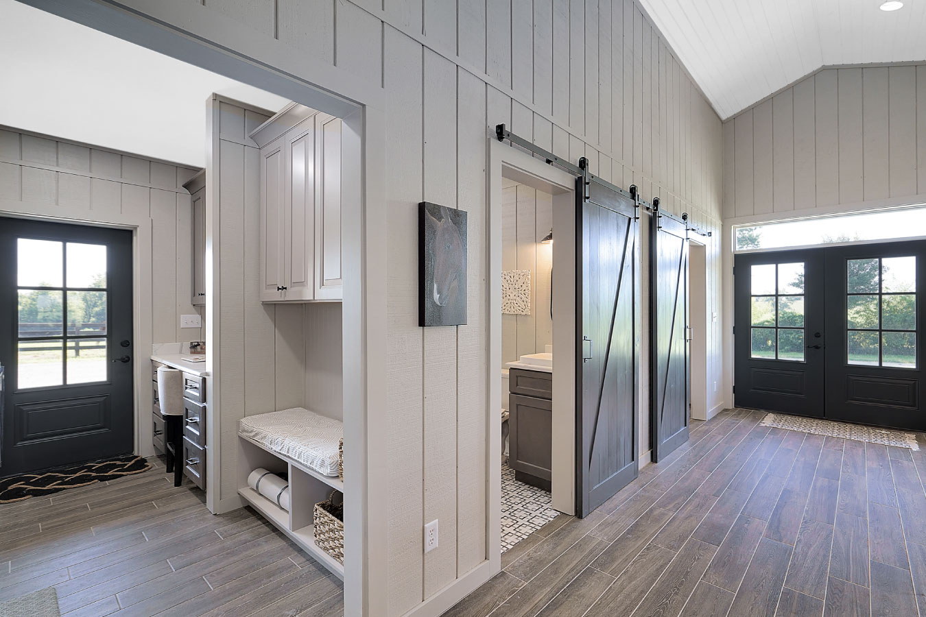 Horse barn living quarters hallway with sliding barn doors and mudroom