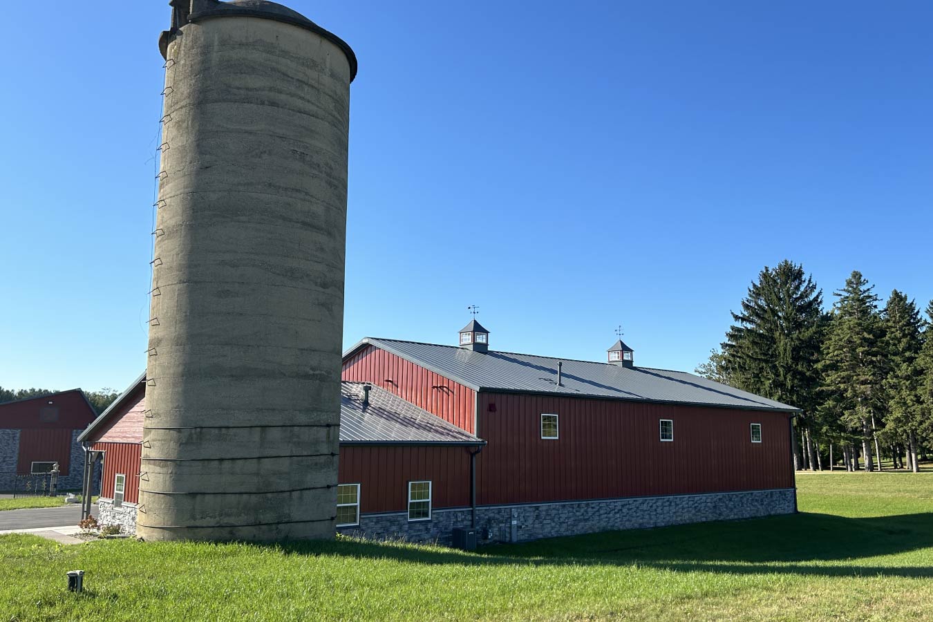 95-1960 Lone Silo Storage facilities in Waukesha Wisconsin with red post frame storage buildings, gray metal roofs, and concrete farm silo.