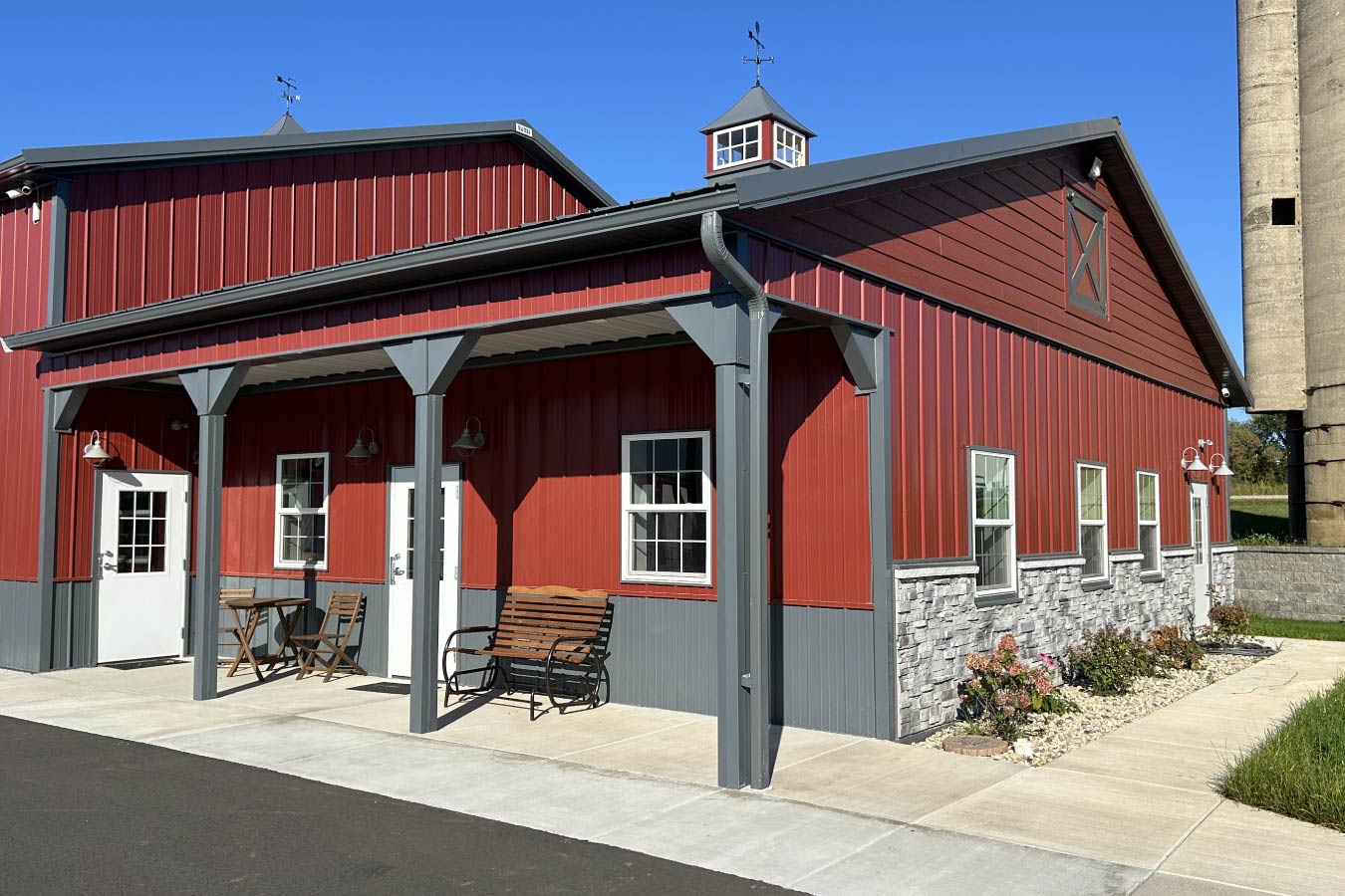 Lone Silo Storage facility office building in Waukesha Wisconsin with red post frame construction, gray metal roof, covered porch, and stone wainscot.