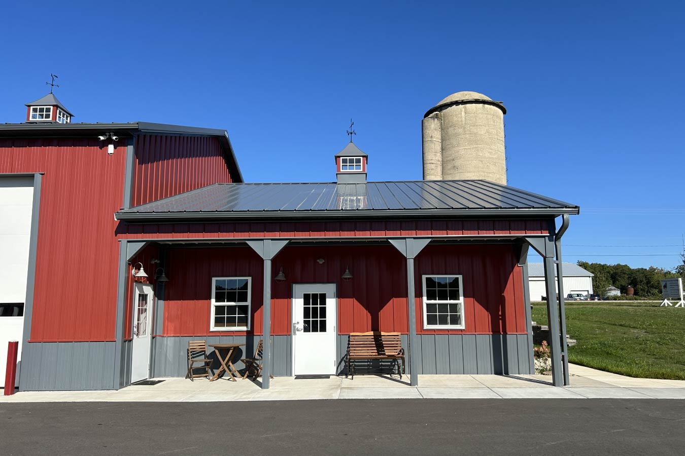 Lone Silo Storage facility office building in Waukesha Wisconsin with red post frame construction, gray metal roof, covered porch, and stone wainscot.