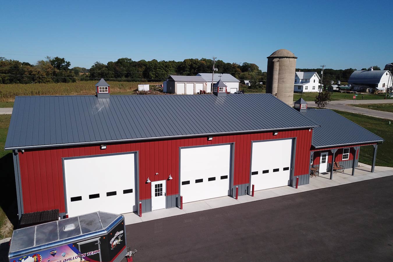 Lone Silo Storage facility in Waukesha Wisconsin with red post frame storage building, gray metal roof, and multiple large storage unit doors.