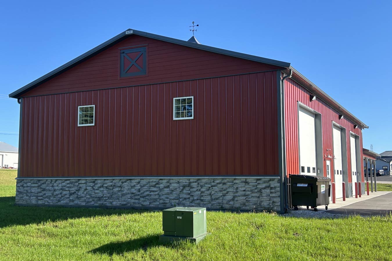 Lone Silo Storage facility in Waukesha Wisconsin featuring a red post frame storage building with gray metal roof, stone wainscot, and large storage unit doors.