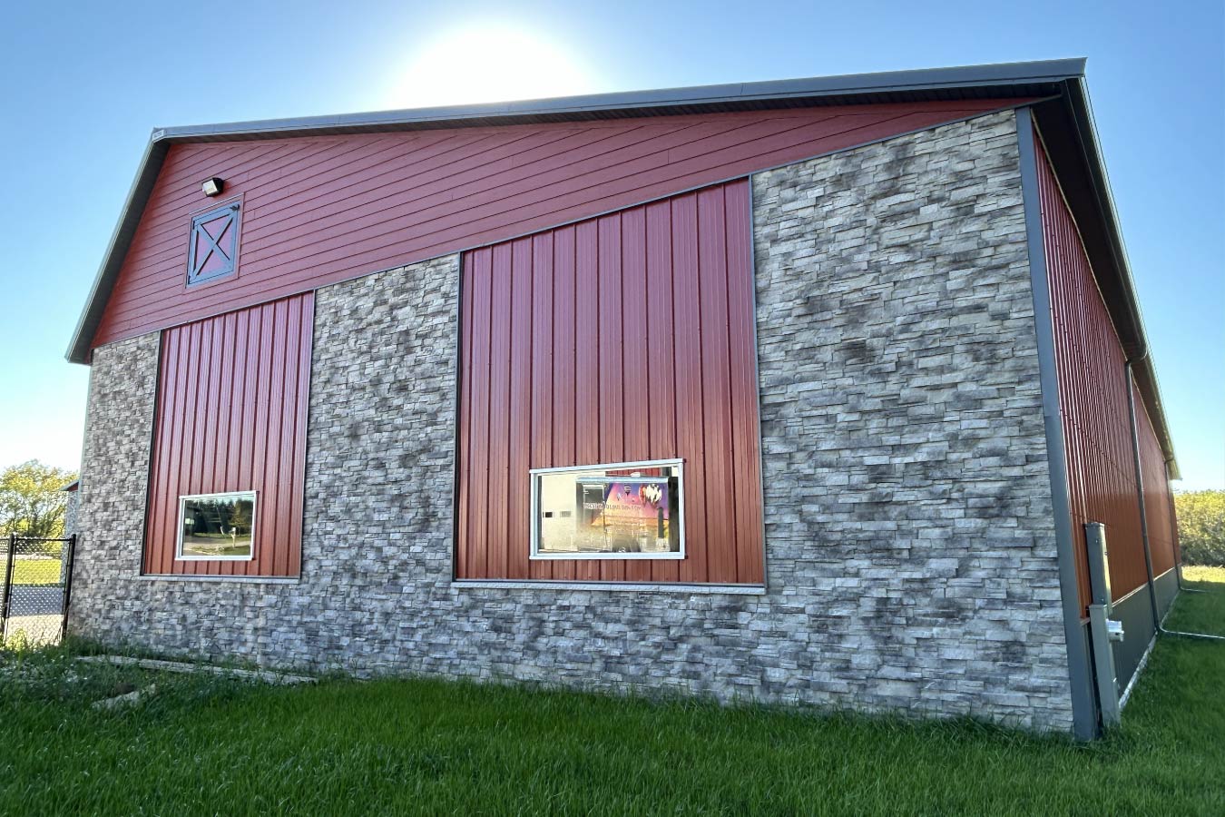 Lone Silo Storage facility in Waukesha Wisconsin featuring a red post frame storage building with decorative stone exterior and gray metal roof. Masonry Trim Package