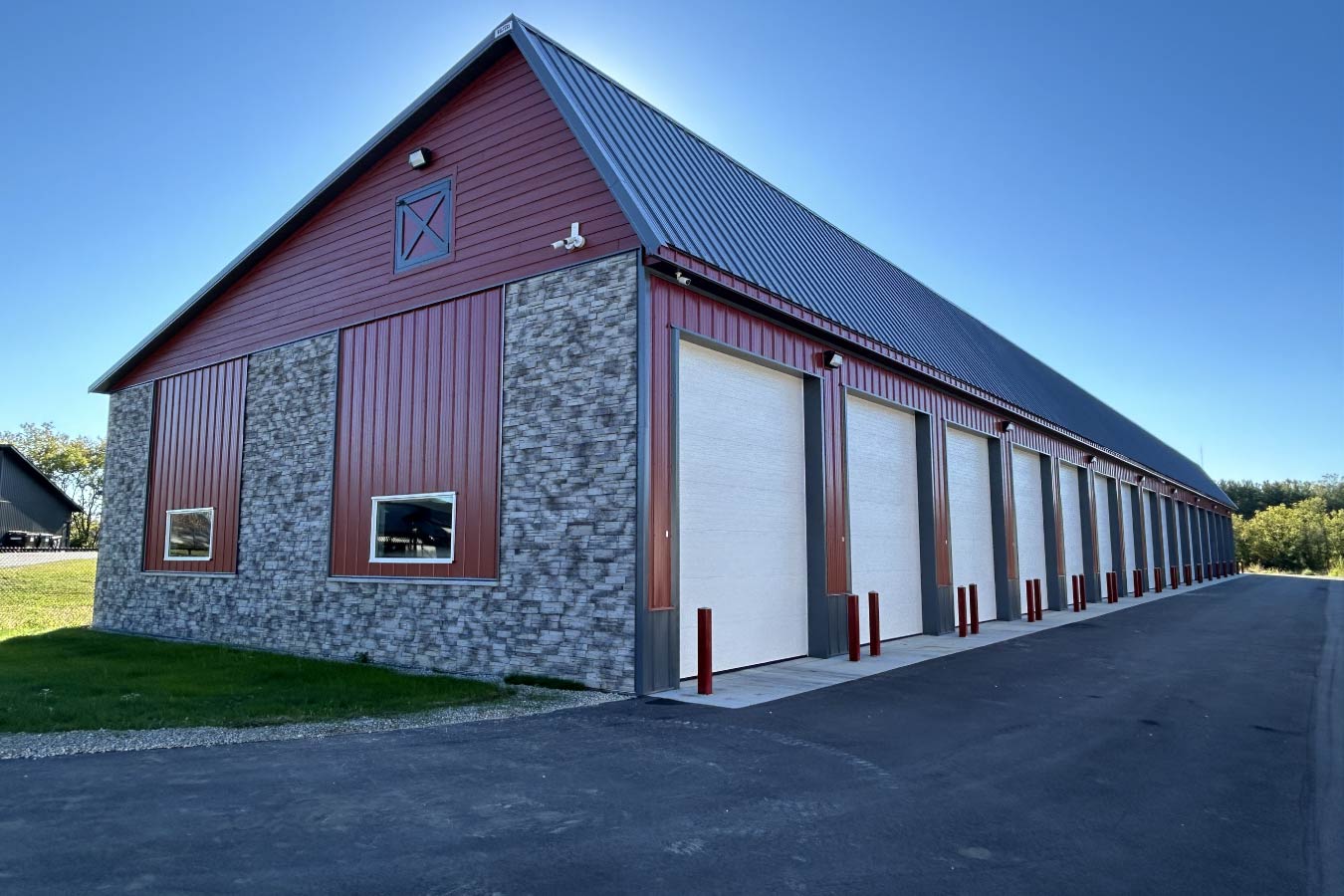 Lone Silo Storage facility in Waukesha Wisconsin with red post frame storage building, stone exterior accents, gray metal roof, and multiple storage unit doors.