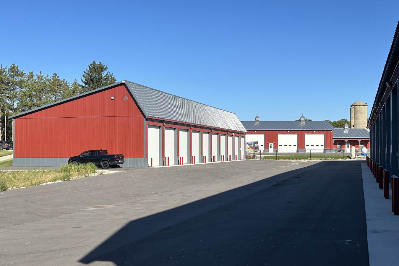 Lone Silo Storage facilities in Waukesha Wisconsin with multiple red post frame storage buildings and gray metal roofs.
