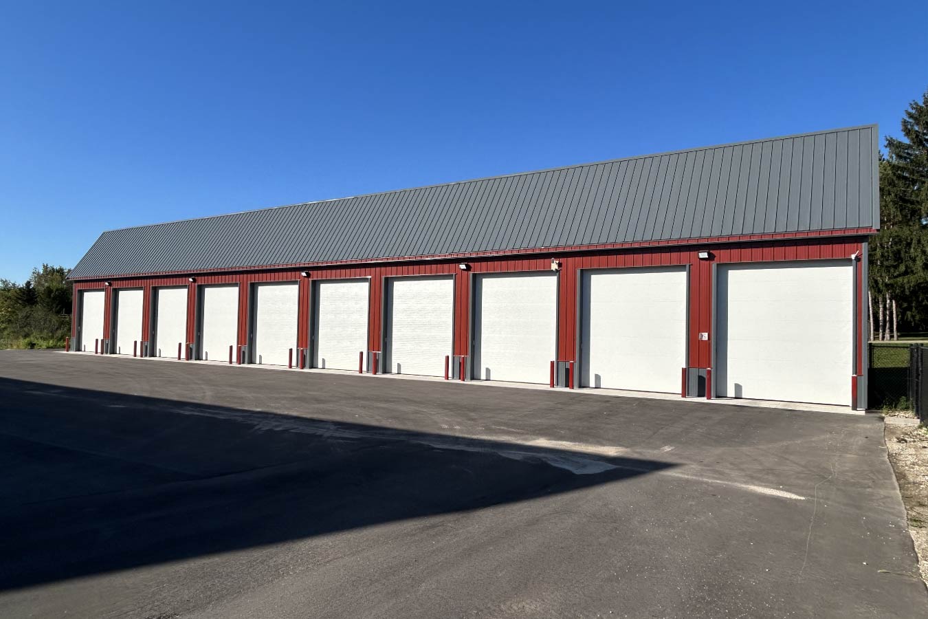 Lone Silo Storage facility in Waukesha Wisconsin featuring a long red post frame storage building with gray metal roof and multiple storage unit doors. 10 Storage Units measuring 15'x50'