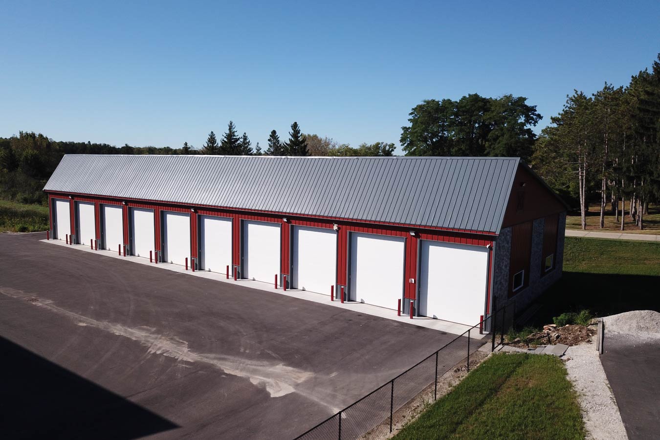 Lone Silo Storage facility in Waukesha Wisconsin featuring a long red post frame storage building with gray metal roof and multiple storage unit doors. 50' x 240' Solar Front Storage Units