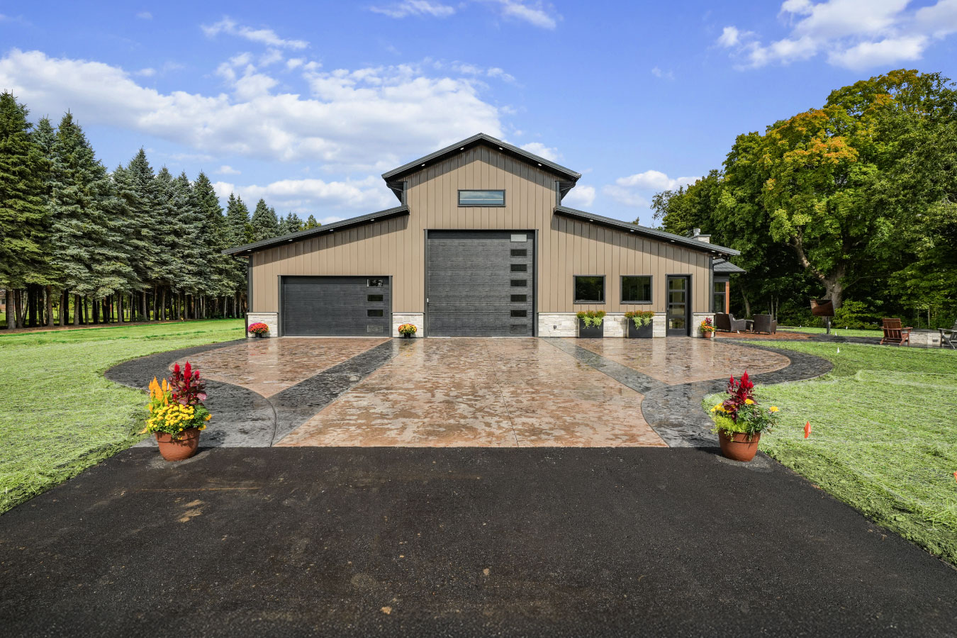 94-0732 Monitor barndominium with raised center roof section, tan steel siding, and black garage doors