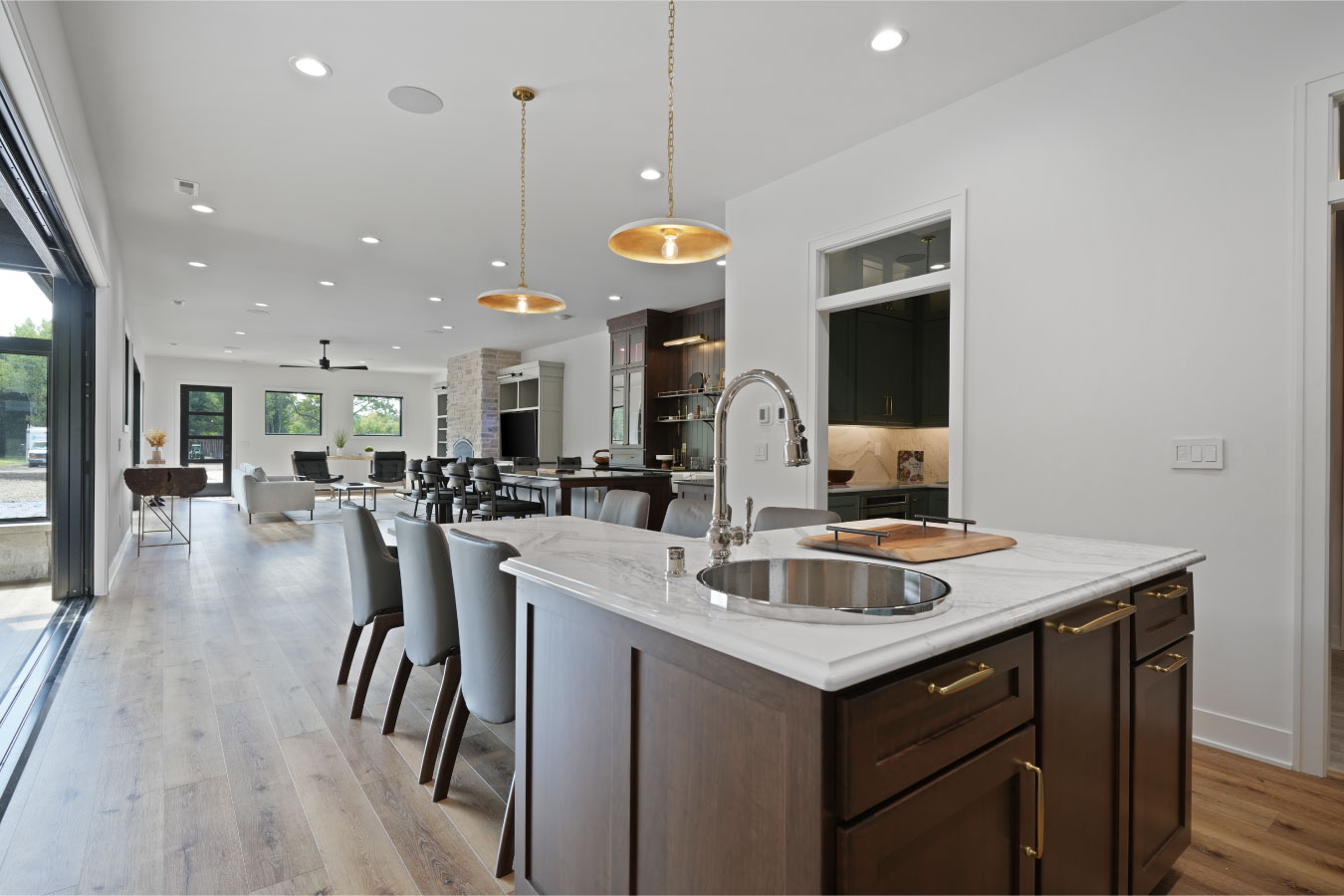 Open concept kitchen island inside a custom monitor barndominium with marble countertops and bar seating