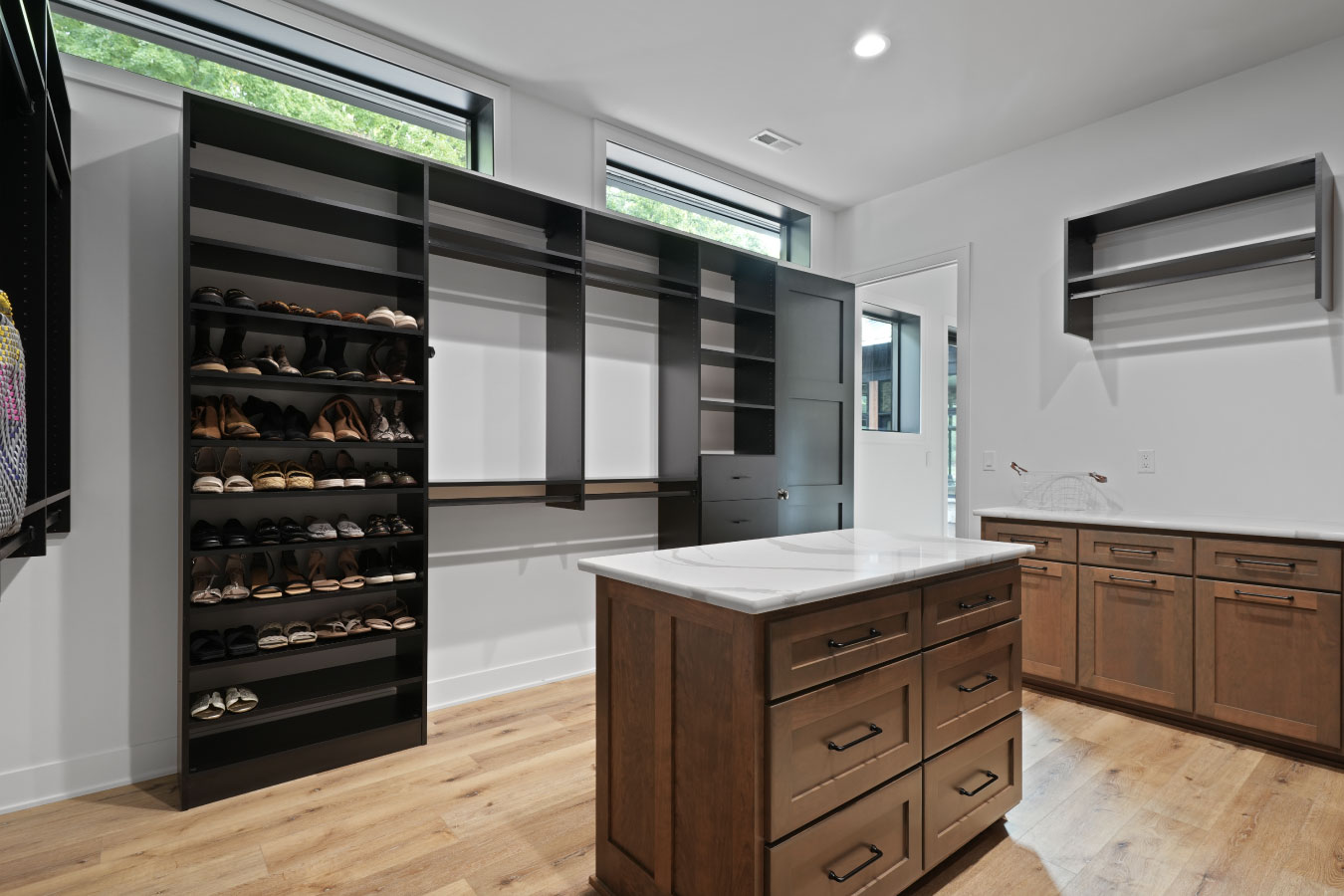 Walk-in closet inside a custom monitor barndominium with built-in shelving and center island