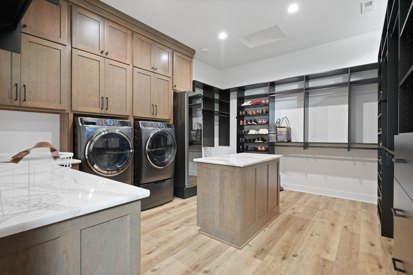Laundry room and storage area inside a custom monitor barndominium with washer, dryer, and cabinetry