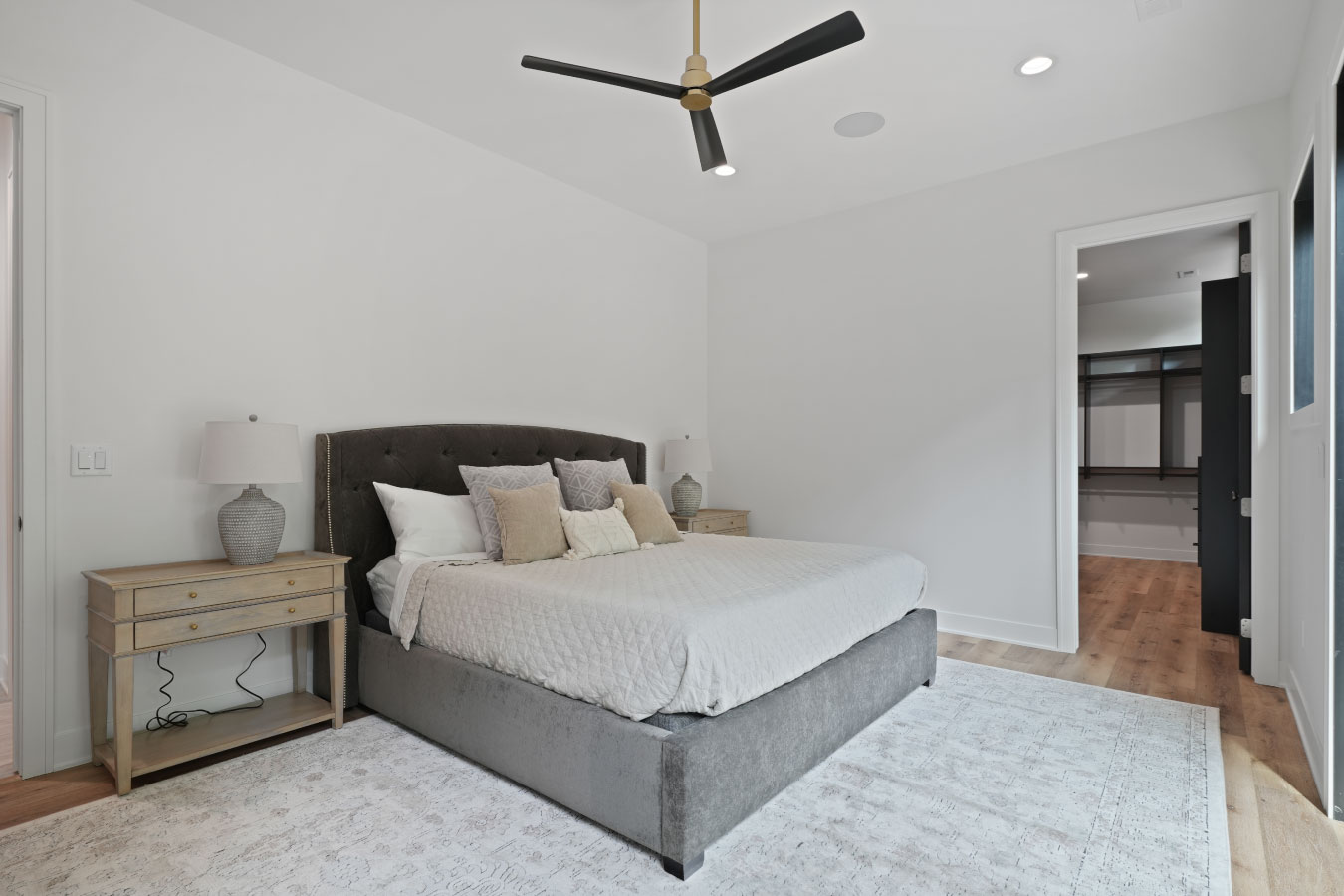 Primary bedroom inside a custom monitor barndominium with modern design and walk-in closet access